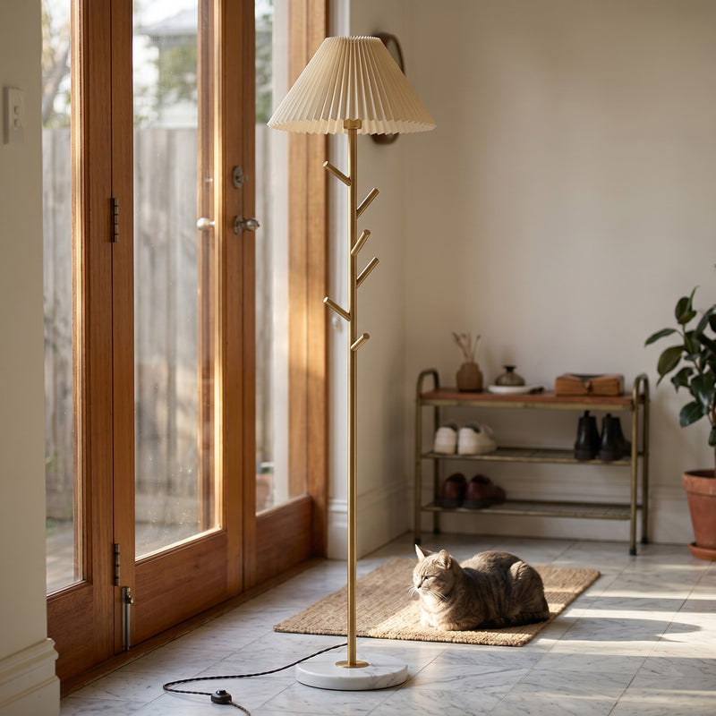 Floor lamp with pleated shade in a room with a cat sitting on the floor.