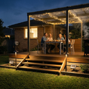 Family enjoying a meal on a wooden deck with string lights at night.