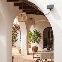 PT0914 solar rattan pendant lights glowing in an outdoor glass garden room at night