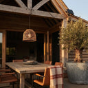 PT0913 solar rattan pendant lamp providing warm ambient lighting above an outdoor dining table