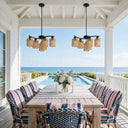 Rustic woven pendant light hanging in high ceiling stairwell with black iron railings