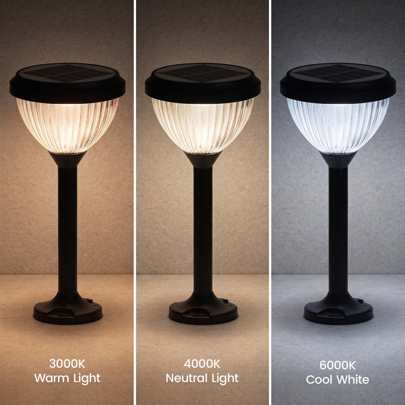 Three solar outdoor landscape lights shown side by side in warm, neutral, and cool white light modes, each with a black ribbed glass shade and base on a plain surface.