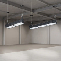 Two long rectangular industrial LED underfloor lights suspended from the ceiling of a large concrete warehouse or studio space.
