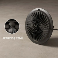A round black fan-like device with a ribbed interior and a visible cable, shown on a neutral gray surface. A circular inset highlights a breathing valve detail, with the text 'Breathing Valve' overlaid.