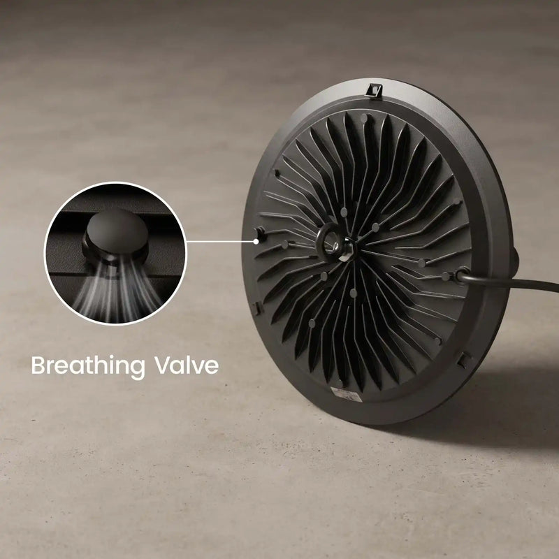 A round black fan-like device with a ribbed interior and a visible cable, shown on a neutral gray surface. A circular inset highlights a breathing valve detail, with the text 'Breathing Valve' overlaid.