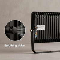 Black outdoor LED light bar with a circular inset showing a breathing valve, on a textured gray background.