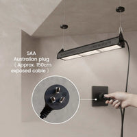 A black linear LED grow light hanging from a ceiling in a minimalist beige room, with a hand plugging its Australian-style power cord into a wall outlet. An inset circle highlights the exposed plug, and text notes the SAA Australian plug and approximate 150cm exposed cable.