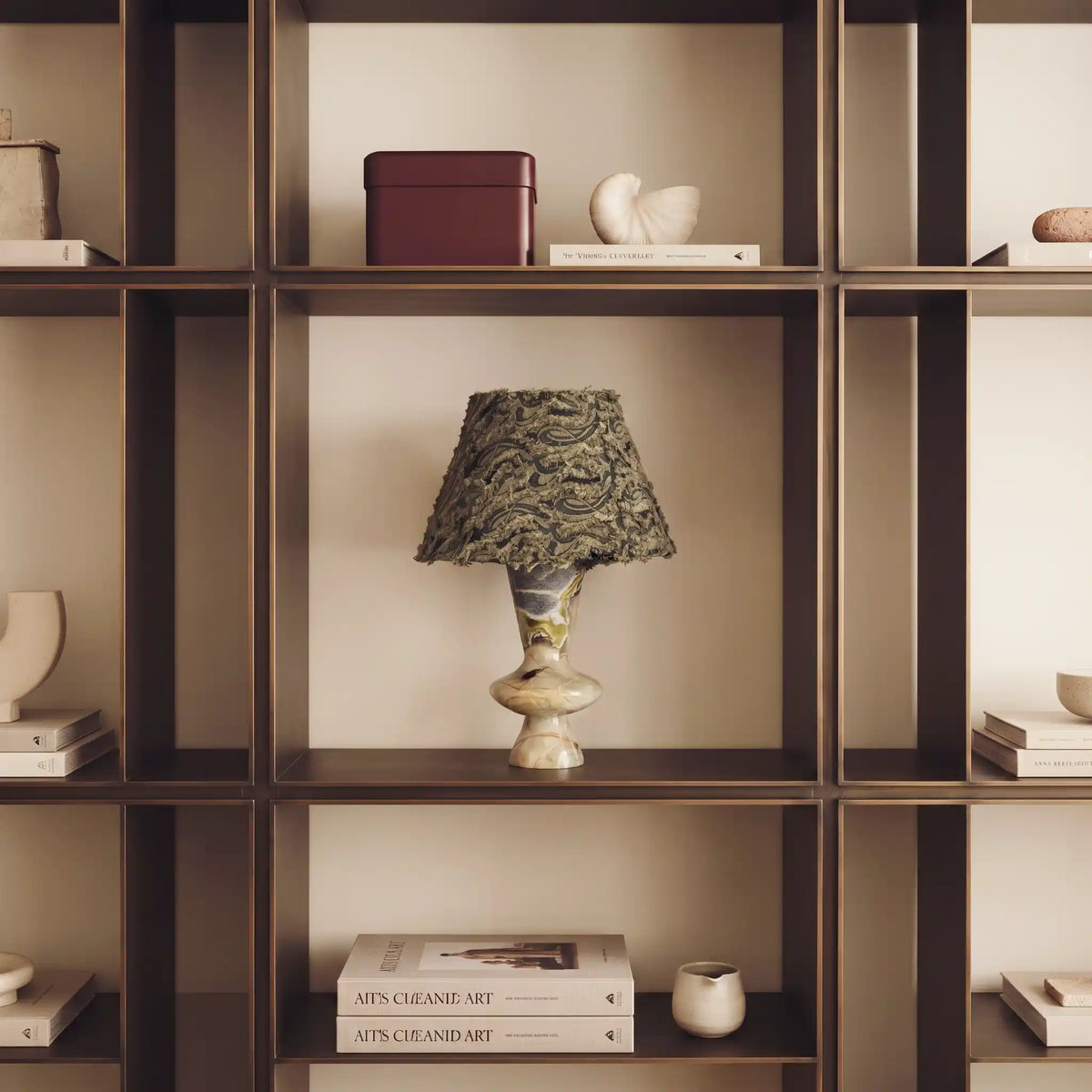 Forest Ember Twilight Marble table lamp displayed in a warm built-in bookshelf