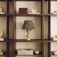 Forest Ember Twilight Marble table lamp displayed in a warm built-in bookshelf