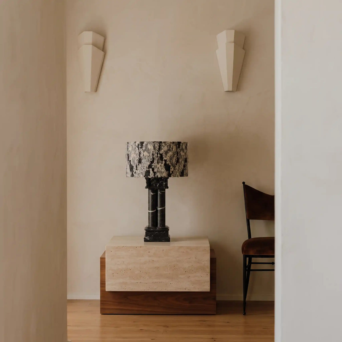 Silent Rift Black Vein Marble table lamp on a pedestal in a minimalist neutral interior