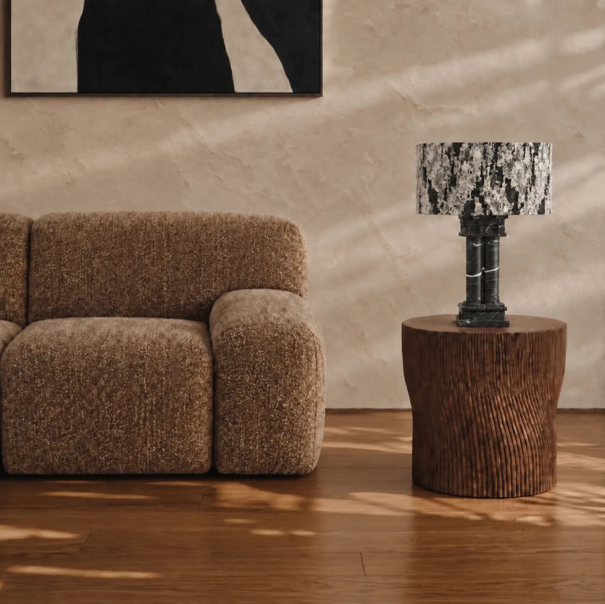 Silent Rift Black Vein Marble table lamp on a round wood side table beside a brown lounge chair