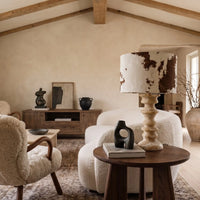 Desert Veil travertine table lamp on a wooden side table in a neutral living room